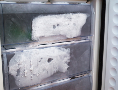 Cropped shot of a freezer drawer covered in ice